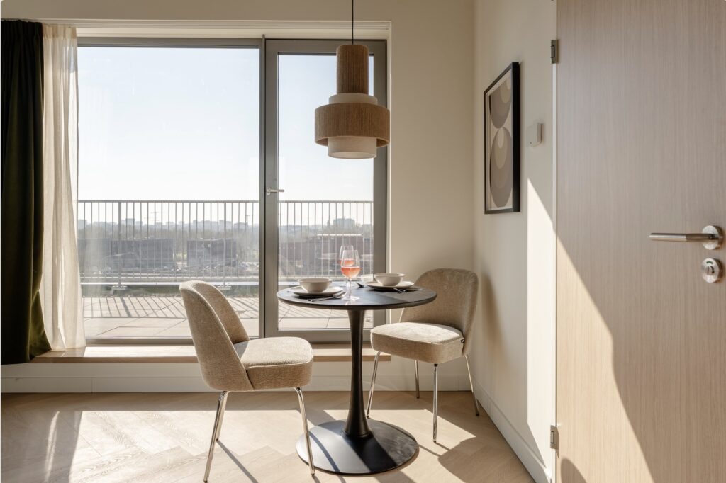 Lichte eetkamer van een serviced apartment in Makerstoren Amsterdam met uitzicht over Sloterdijk
