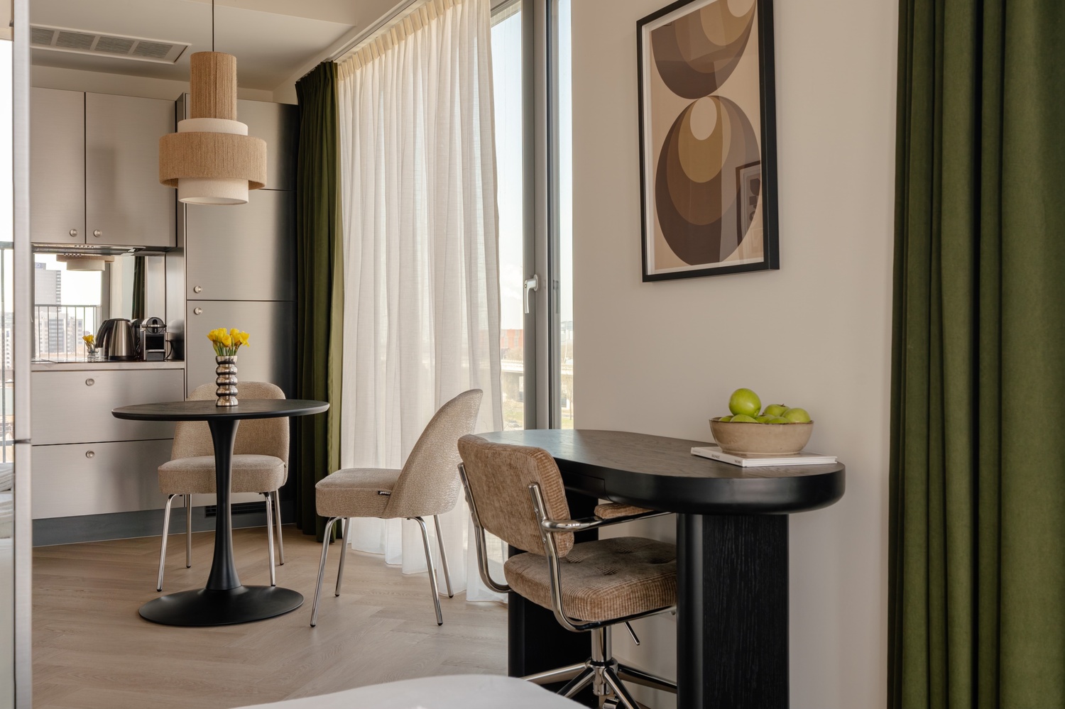 Eethoek en bureau bij het raam van de Superior Studio with Balcony in Makerstoren, met uitzicht op de stad