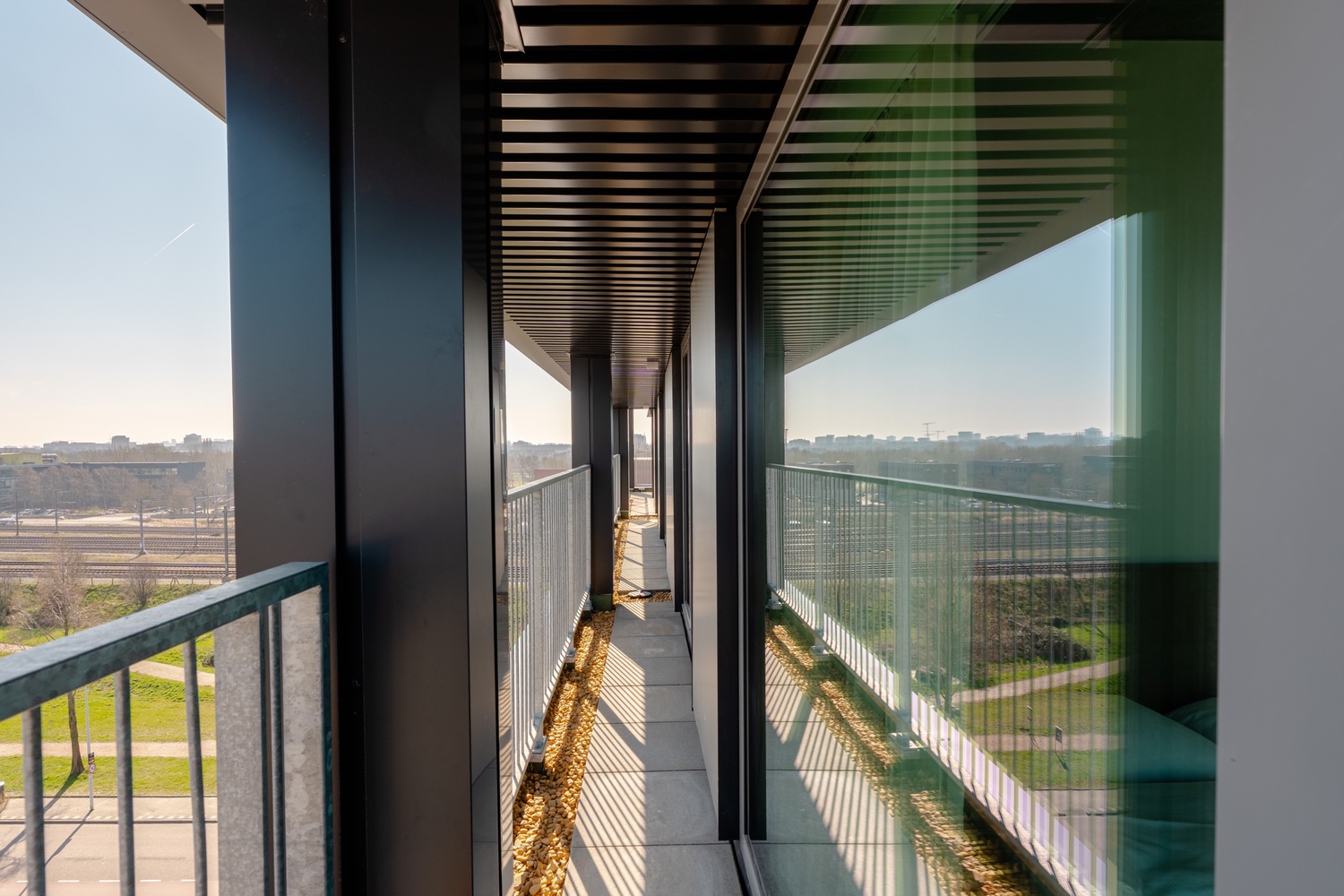 Eigen balkon van de Superior Studio with Balcony in Makerstoren, met glazen balustrade en uitzicht over Amsterdam