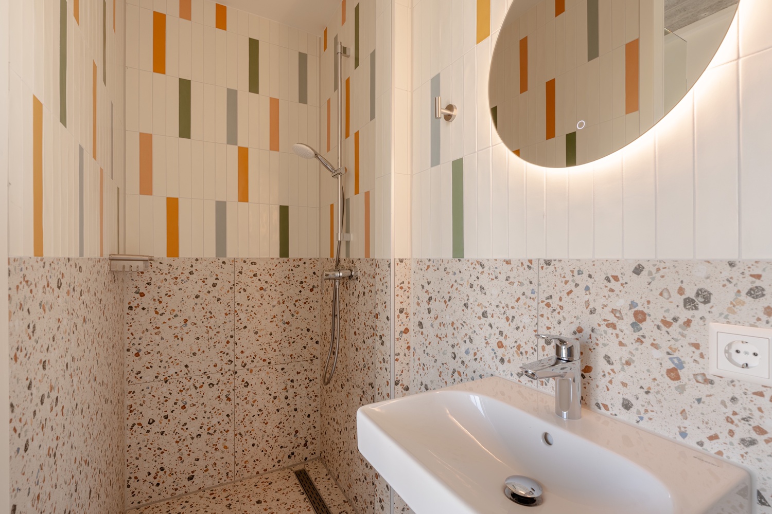 Douche met kleurrijke tegels en terrazzo in de en-suite badkamer van de Superior Studio with Balcony, Makerstoren