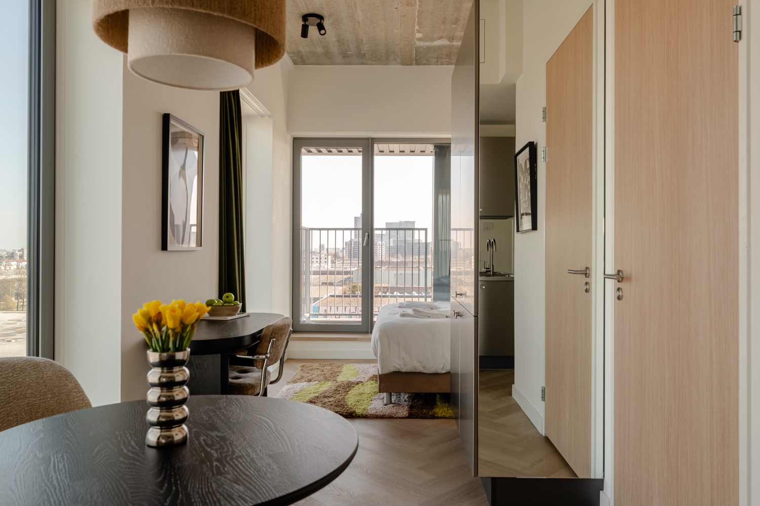Hal met eethoek in de Superior Studio with Balcony van Makerstoren, met doorkijk naar slaapkamer en keuken