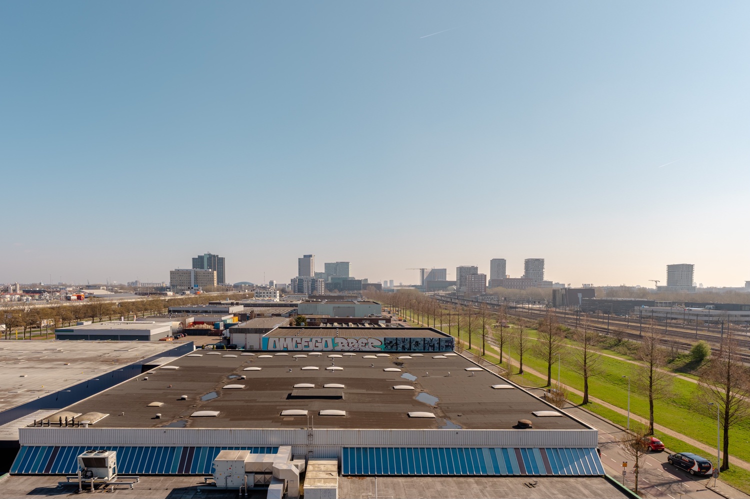 Uitzicht vanuit de Superior Studio with Balcony in Makerstoren over de omgeving van Amsterdam Sloterdijk, met de skyline op de achtergrond