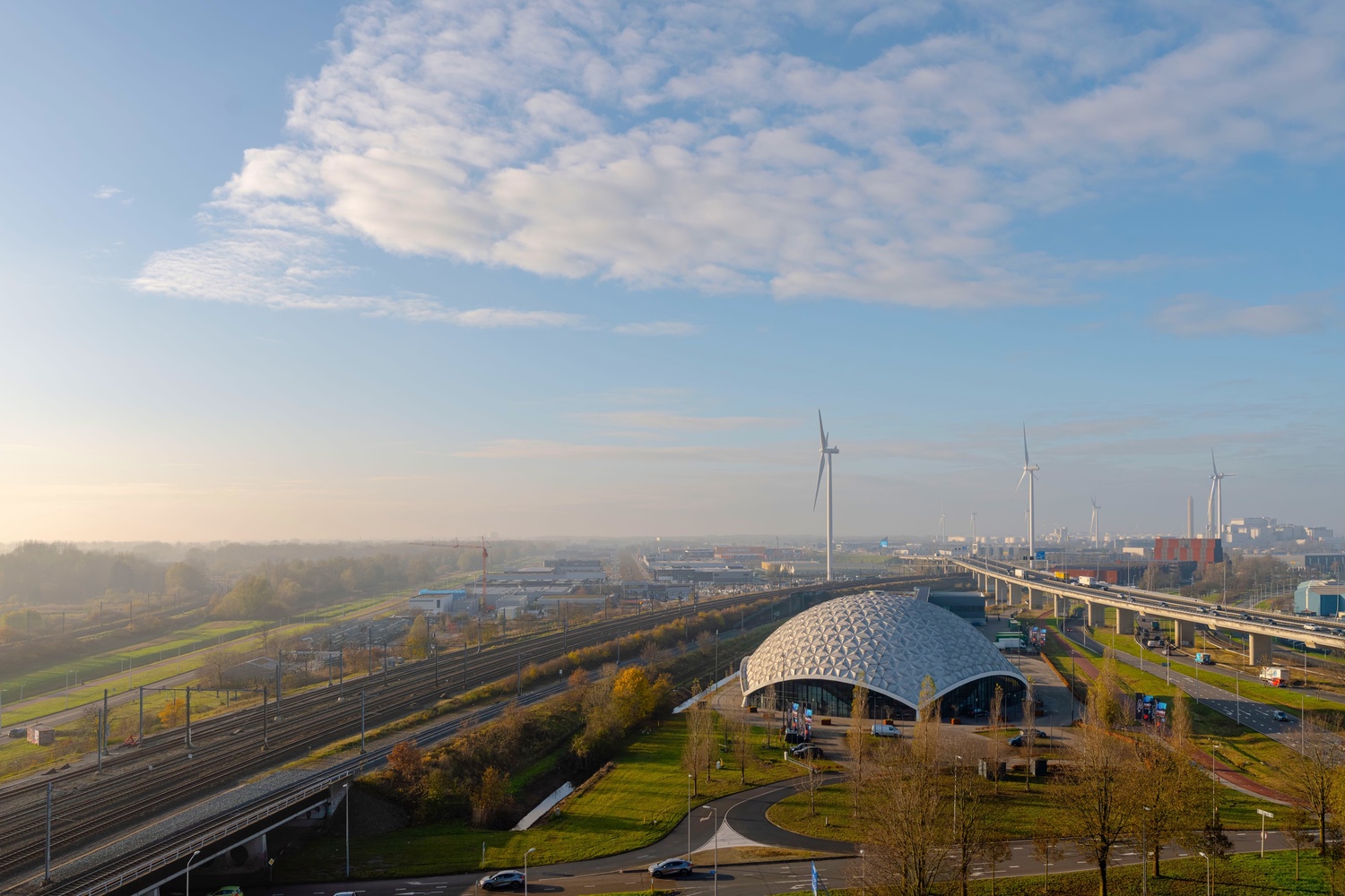 Uitzicht vanuit de Superior Studio in Makerstoren over de omgeving van Amsterdam Sloterdijk, met windmolens en spoorlijnen