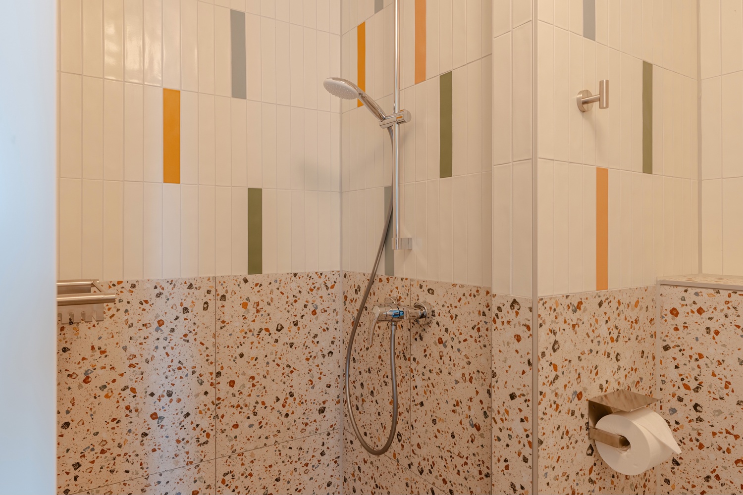 Douche met kleurrijke tegels en terrazzo in de en-suite badkamer van de Standard Studio with Balcony, Makerstoren