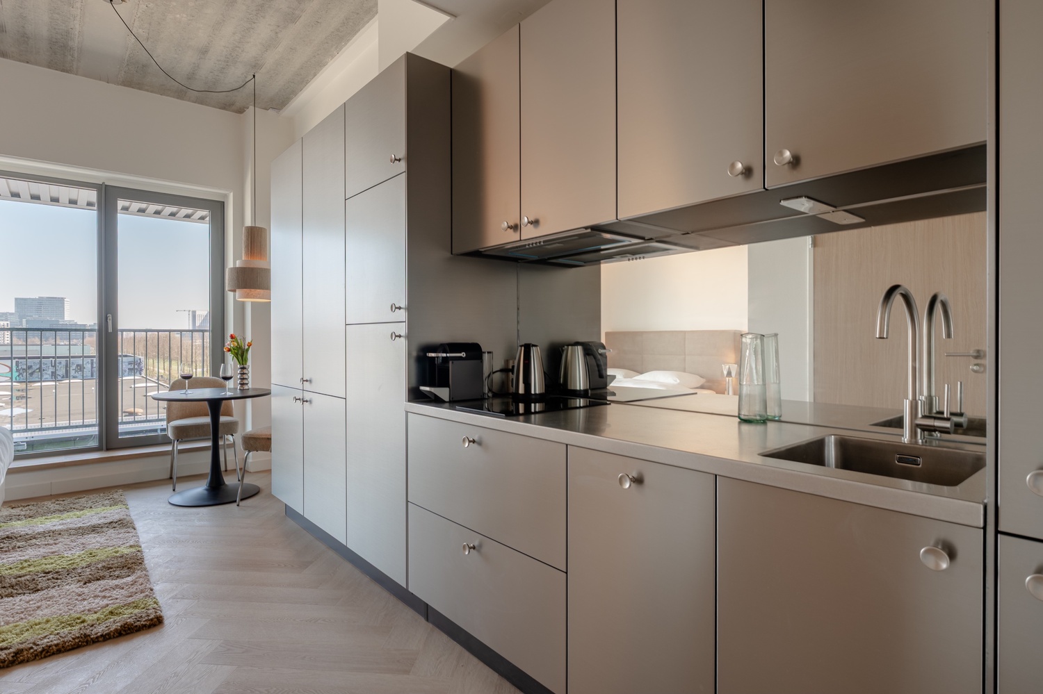 Privékeuken met spoelbak en kookplaat in de Standard Studio with Balcony, met zicht op het balkon en de skyline
