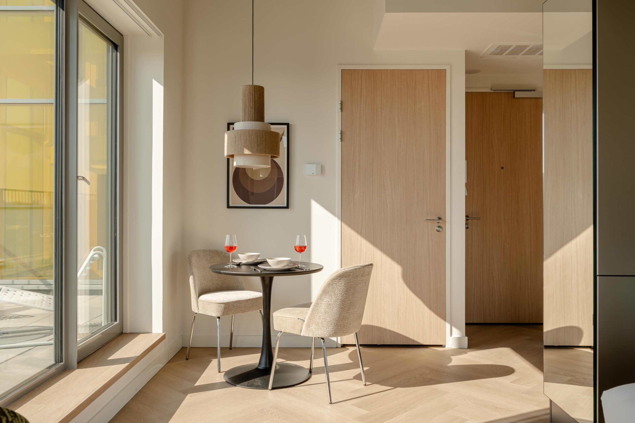 Eethoek en entree short-stay appartement Amsterdam – Executive Corner met spiegelwand en visgraatvloer