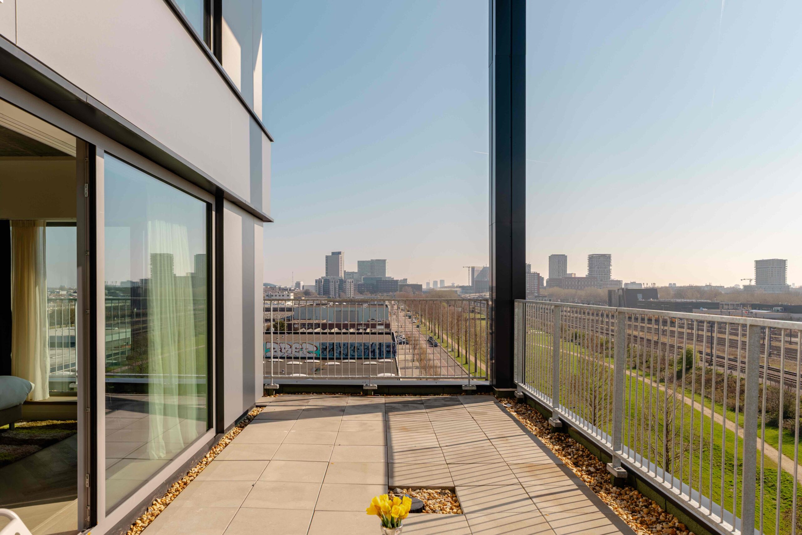 Hoekbalkon short-stay appartement Amsterdam – Executive Corner met glazen balustrade en skyline