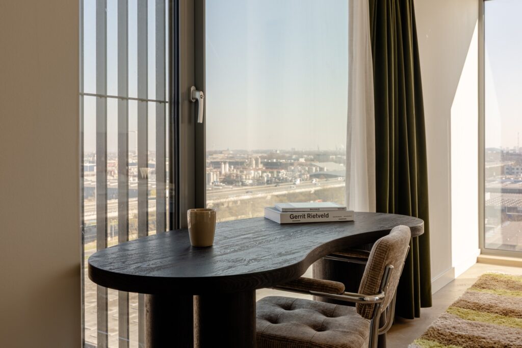 Bureau bij het raam met uitzicht op snelweg en skyline in studio appartement Amsterdam Sloterdijk